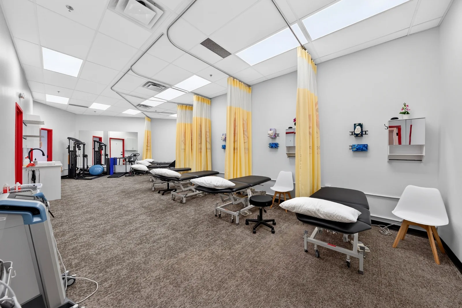 Real photograph inside Power Physiotherapy and Massage, showing treatment tables, privacy curtains and exercise equipment